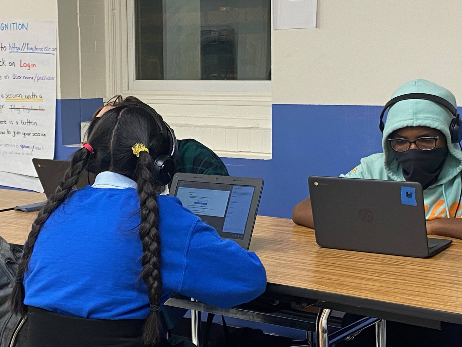 Students working on their laptops while wearing headphones