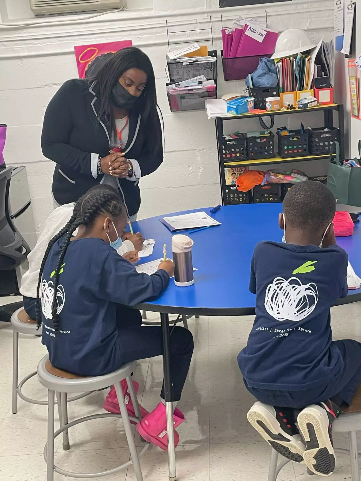 Tutor works with students studying at a table