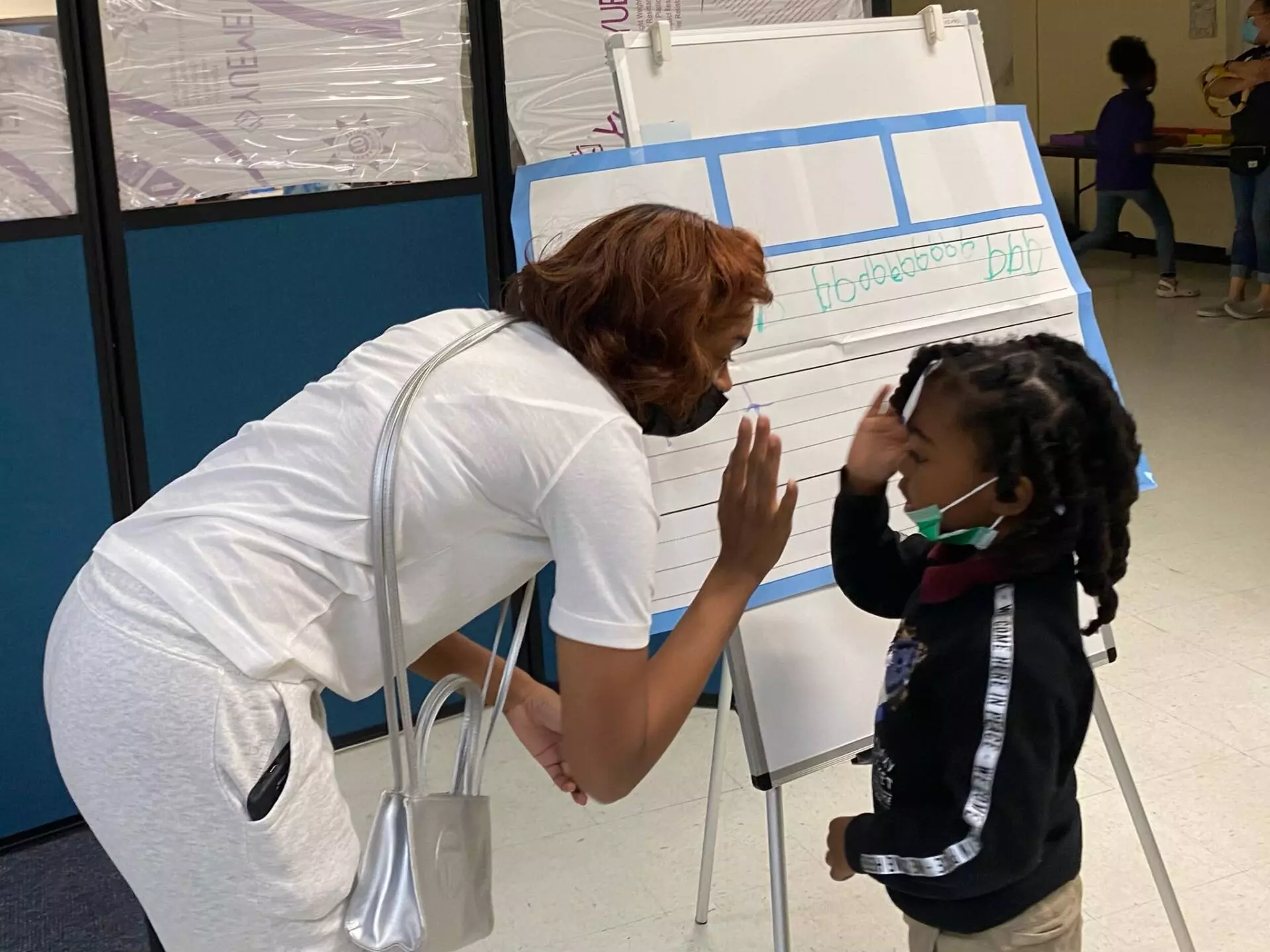 Tutor gives student a "high-five" while working on writing